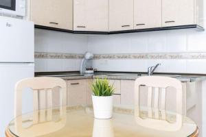 a kitchen with a glass table and two chairs at APARTAMENTOS CARMEN in Maro