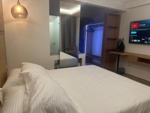 a bedroom with a white bed and a large mirror at Archontiko Liamas in Stavros