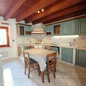穆贾B&B Raggio di sole的厨房配有绿色橱柜和桌椅