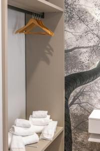 een badkamer met handdoeken op een plank met een boommuurschildering bij Guest House Colosseo Terrestre in Rome