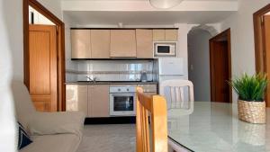 a kitchen with a table and a dining room at APARTAMENTOS CARMEN in Maro