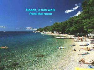 a beach with people laying on the sand and the water at Villa Belvedere in Lokva Rogoznica