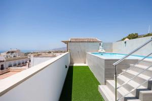 a view from the balcony of a house with a swimming pool at APARTAMENTOS CARMEN in Maro