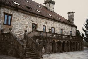an old stone building with a staircase in front at Pazo Arretén in Padrón