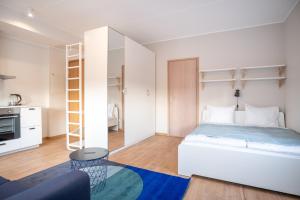 a white bedroom with a bed and a table at Spacious Mustamäe Apartments - Free parking in Tallinn