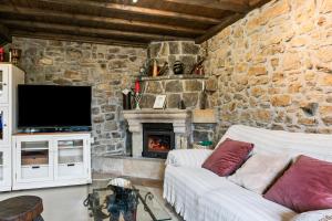 a stone walled living room with a couch and a fireplace at Casa Rural Adrimar in Selorio