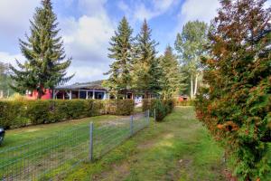 a fence in front of a house with a yard at Korswandt, Ostseebungalow in Korswandt