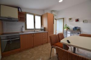 a kitchen with wooden cabinets and a table with chairs at Apartments Bella Vista Lilly in Portorož