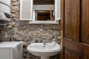 a bathroom with a sink and a stone wall at Casa Rural Adrimar in Selorio +36 photos