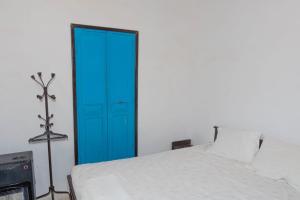 Puerta azul en un dormitorio con cama en dar babey nefta, en Nefta
