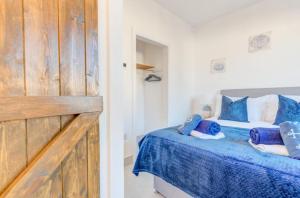 a bedroom with a bed with blue sheets and blue pillows at Sunvalley hideaway in Pembrokeshire