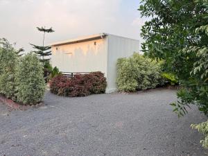 a building with a bench in the middle of some bushes at Elk Seizon Retreat in Kundakal