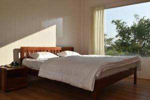 a bedroom with a bed with a large window at Elk Seizon Retreat in Kundakal