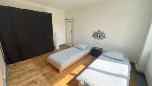1 Schlafzimmer mit 2 Betten und Holzboden in der Unterkunft Gite Chez Krol in Bonnes
