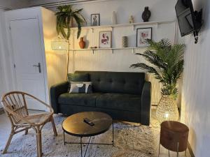 a living room with a green couch and a chair at Havre de Paix - Les Sablon d'A Côté in Amiens