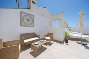 a living room with chairs and a couch and a table at APARTAMENTOS CARMEN in Maro