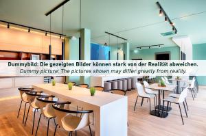 ein Restaurant mit Tischen und Stühlen in einem Raum in der Unterkunft B&B Hotel Essen-Hbf in Essen
