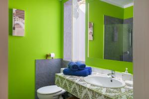 a green bathroom with a sink and a toilet at Casa la Mayor in Costa Teguise