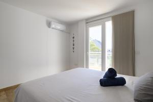a white bed with a blue towel on top of it at Chalet Sol y Beach in San Agustin