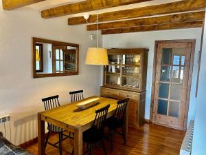 a dining room with a wooden table and chairs at El Mirador d'Olp in Olp