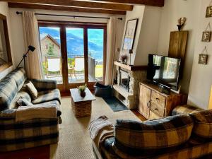 a living room with couches and a flat screen tv at El Mirador d'Olp in Olp