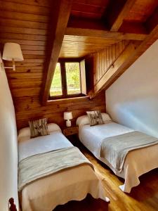 a bedroom with two beds in a wooden cabin at El Mirador d'Olp in Olp