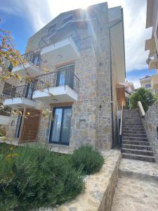 a stone house with stairs in front of a building at olives tree in Datca