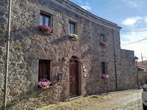a stone building with flower boxes on the windows at Dimora Pietra Antica in Milis
