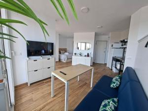 a living room with a blue couch and a table at Apartamento con piscina in Matalascañas