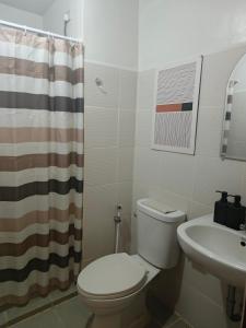 a bathroom with a toilet and a sink at Mesavirre Garden Residences Condo Bacolod in Bacolod +3 photos