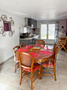 eine Küche mit Esstisch und Stühlen in der Unterkunft Vallée de la Jordanne, Maison cosy 6pers, terrasse in Saint-Julien-de-Jordanne + 13 Fotos