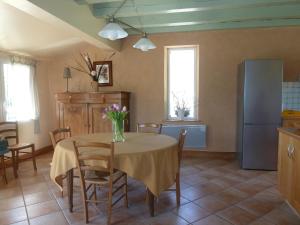 ルブレサックにあるMaison avec piscine privée à Loubressac proche Rocamadour & Vallée Dordogne, du Samedi au Samediのテーブルと椅子のあるキッチンとダイニングルーム