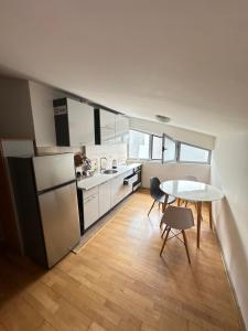 a kitchen with a refrigerator and a table and chairs at Stex Urban 3 in Podgorica