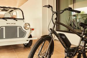 Una bicicleta está aparcada al lado de un coche pequeño. en The Bower Coronado, en San Diego