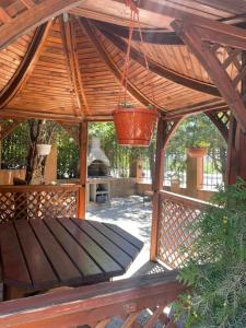 eine hölzerne Pergola mit einer Bank auf der Terrasse in der Unterkunft Pensiunea Lotus Baile 1 Mai in Baile Unu Mai + 3 Fotos