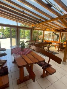 eine Terrasse mit einem Holztisch und Bänken in der Unterkunft Pensiunea Lotus Baile 1 Mai in Baile Unu Mai