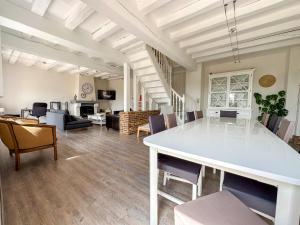 un ampio soggiorno con tavolo e sedie bianchi di Country House with swimming pool a Épeautrolles