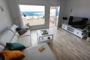 巴哈马尔Relax View的客厅里有一张白色沙发和一台电视 更多10张照片