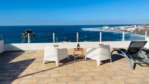 巴哈马尔Relax View的一个带白色椅子和桌子的庭院和大海