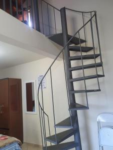 a metal spiral staircase in a room with a bed at Pousada Valle das Pedras in Pedra Bela