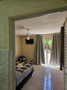 a bedroom with a bed and a sliding glass door at Pousada Valle das Pedras in Pedra Bela