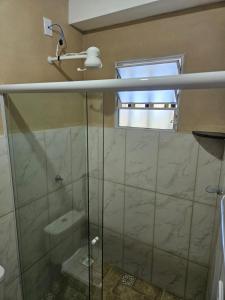 a bathroom with a glass shower with a window at Pousada Valle das Pedras in Pedra Bela