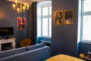 a blue living room with a couch and two windows at Widok na Starówkę Mona Lisa by Rentoom in Toruń