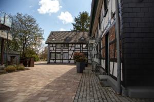 a building with a brick sidewalk next to a building at Kragemann Hotel & Vinothek in Simmerath