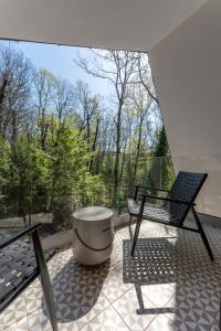 a balcony with two chairs and a table and a window at MÁK Kismaros in Kismaros +32 photos