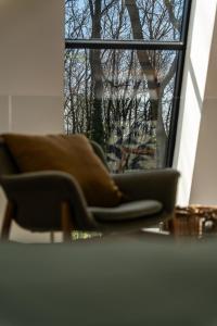 a couch sitting in front of a window at MÁK Kismaros in Kismaros