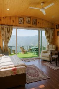 a bedroom with a bed and a balcony with a view at Bougainvilla Mountain Retreat, near Bhimtal in Bhīm Tāl