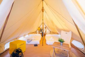 a tent with two beds and a table in it at Kampaoh Oyambre in El Tejo