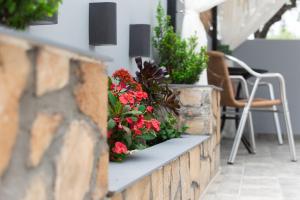 a retaining wall with flowers on a patio at Paradise Apartment, Lardos Village in Lartos