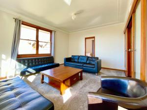 a living room with a couch and a coffee table at Mount St. Raphael's in Leura
